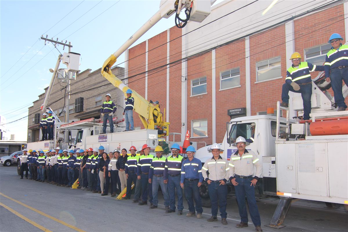 Equipo de COMSEGSA junto a sus vehículos y grúas de trabajo